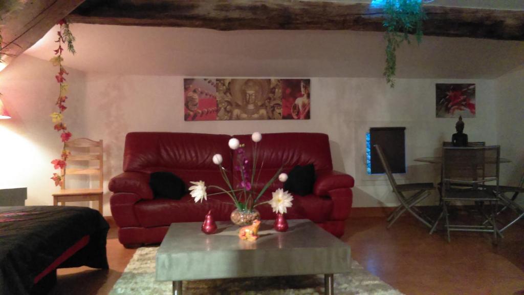 sala de estar con sofá rojo y mesa en Bien-être, en Alignan-du-Vent