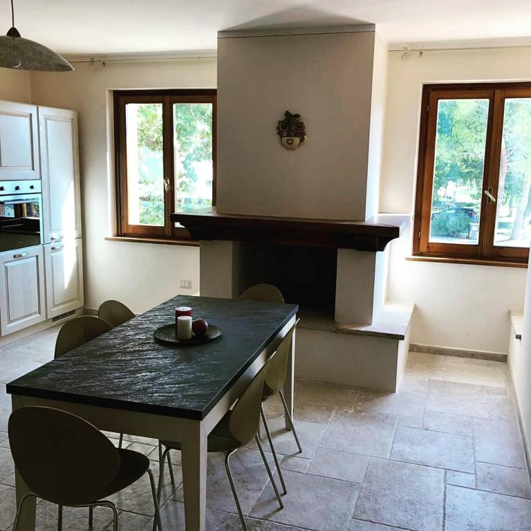 een keuken met een tafel en stoelen in een kamer bij La Grande Quercia in Montefalco