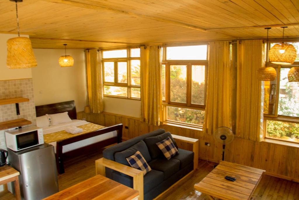 ein Wohnzimmer mit einem Sofa und einem Tisch in der Unterkunft Nile Front Cottages in Jinja