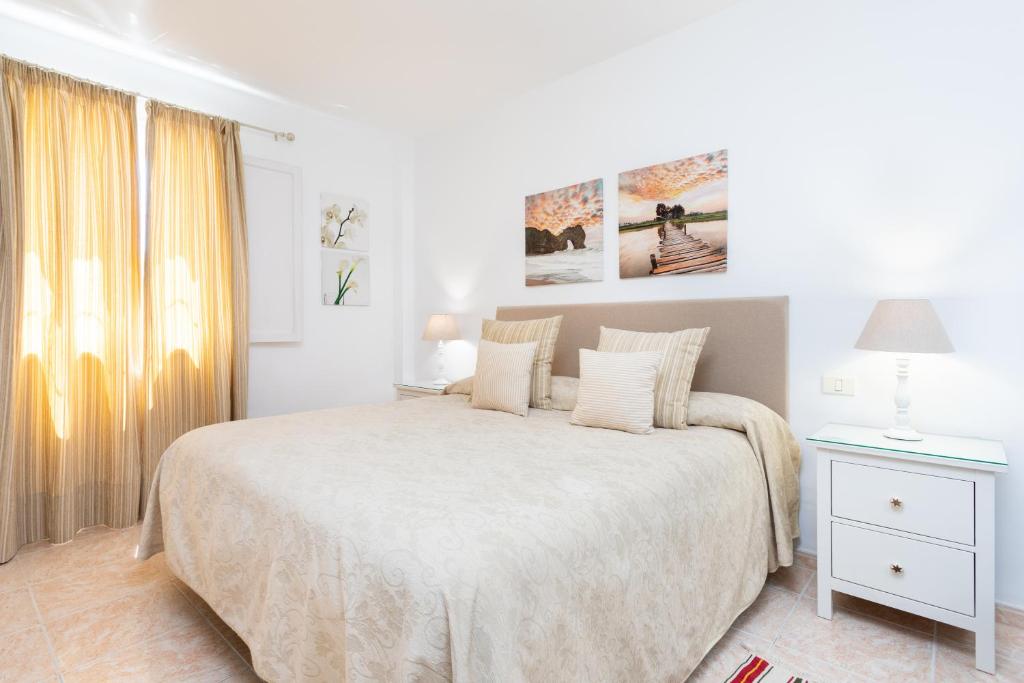 a white bedroom with a large bed and a window at Vivienda vacacional La Laguna Luxe in La Laguna