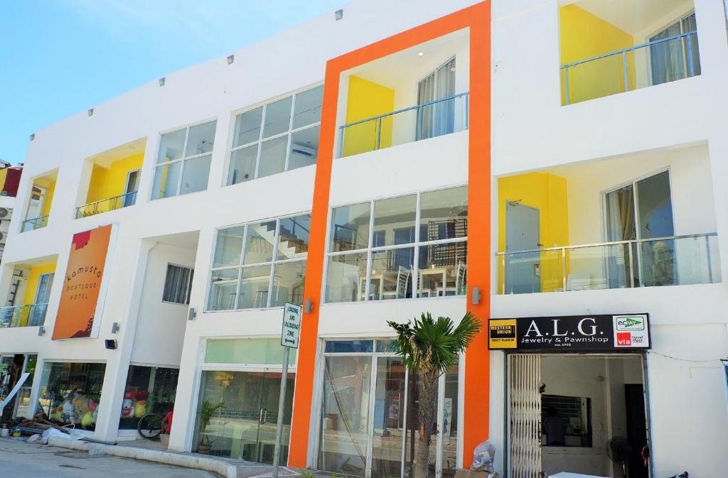 an apartment building with orange columns on a street at Kamusta Boutique Hotel in Boracay