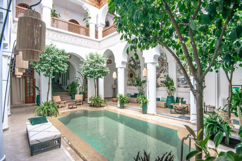 an indoor pool in the courtyard of a building with trees at Riad Palais Calipau in Marrakesh