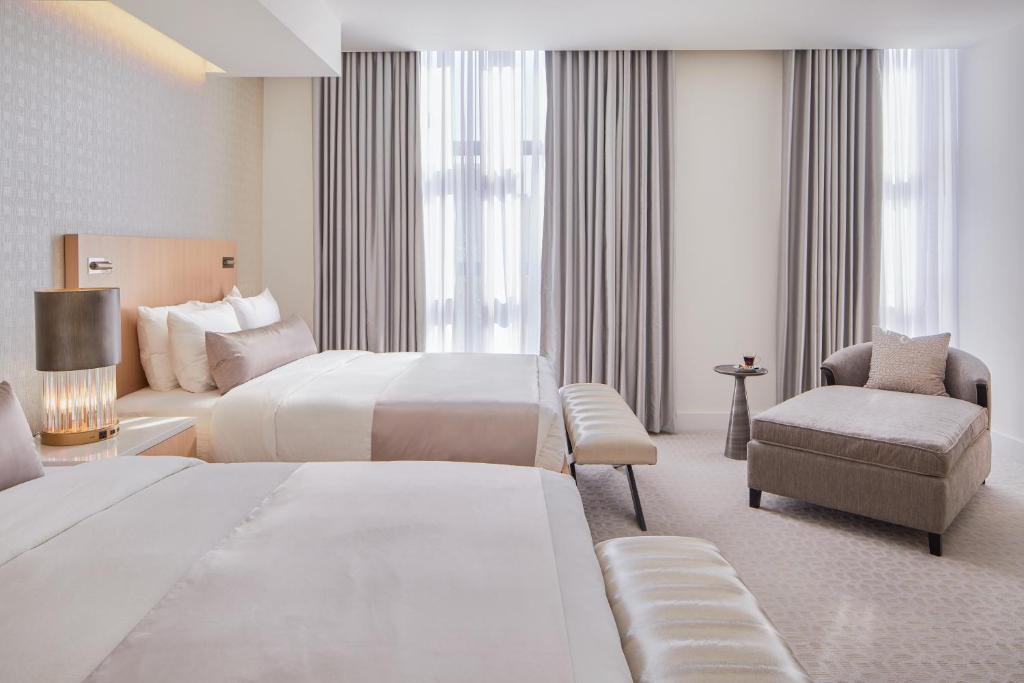 林垦The Kindler Hotel的有两张床和一把椅子的酒店房间