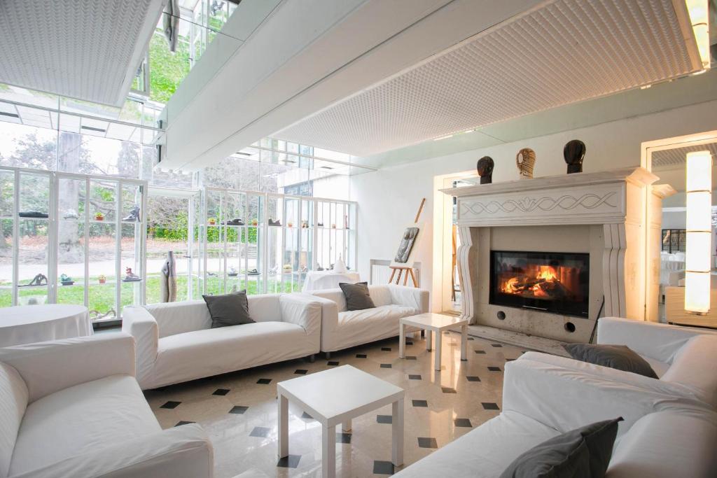 a living room with white couches and a fireplace at Albergo Ristorante Madonnina in Cantello