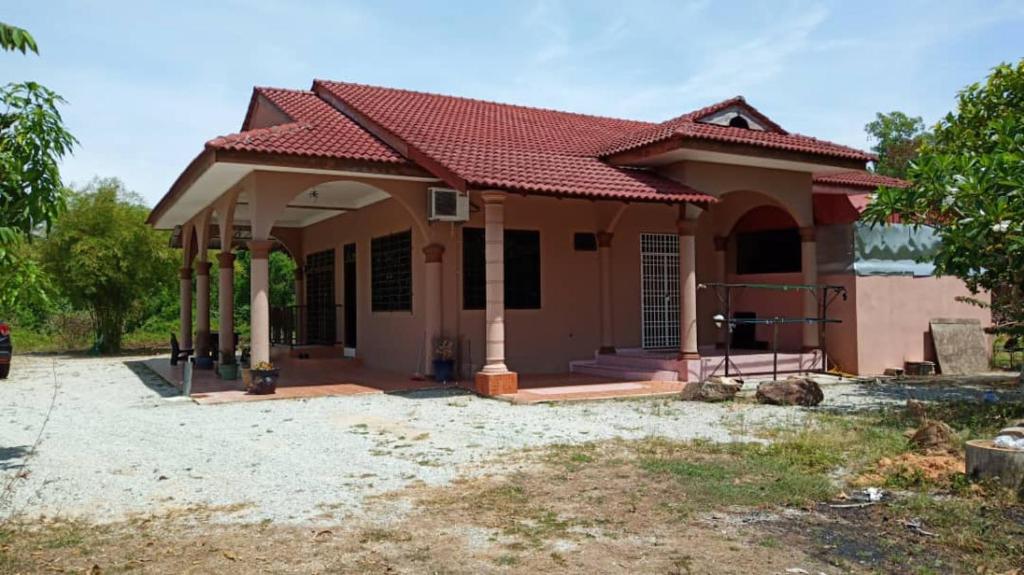 een klein huis met een rood dak bij Homestay Zahra Sri Bayu in Kampong Dalam Ru
