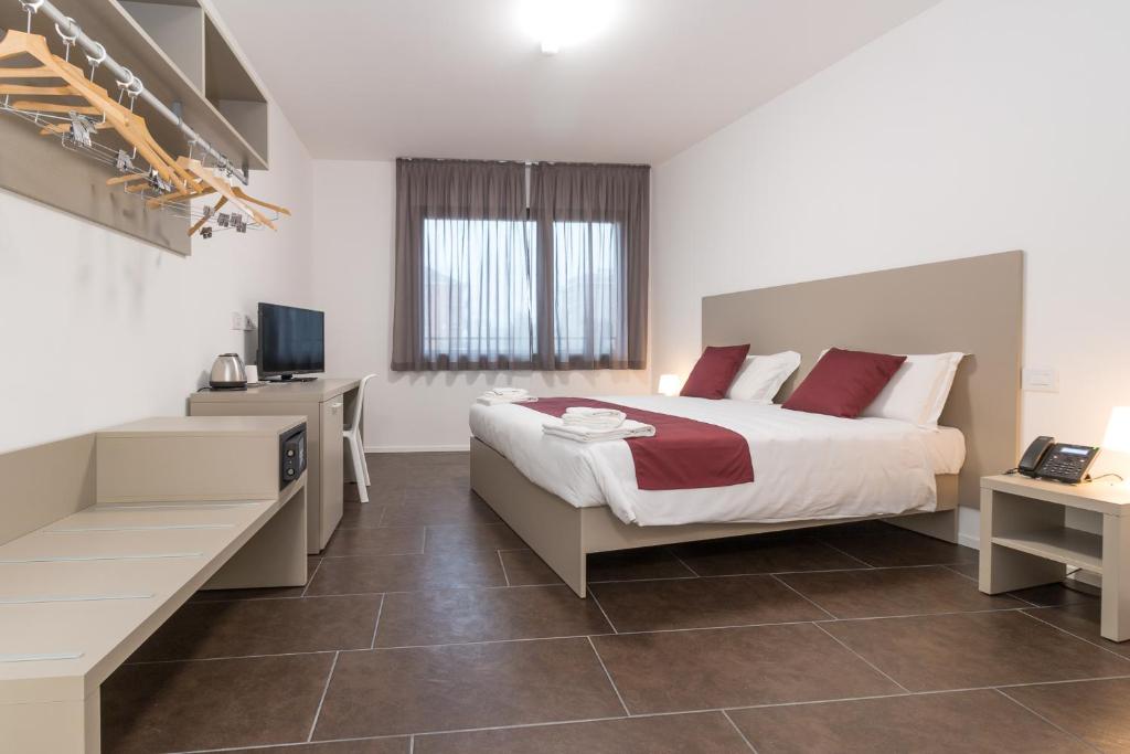 sypialnia z łóżkiem, biurkiem i telewizorem w obiekcie Hotel Cascina Fossata & Residence w Turynie