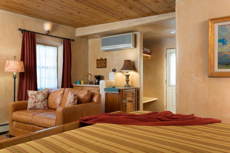1 dormitorio con 1 cama y 1 sofá en una habitación en El Farolito B&B Inn, en Santa Fe
