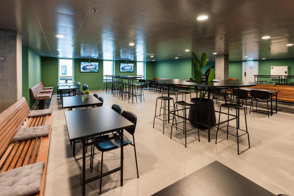 a restaurant with tables and chairs and green walls at Cabinn Copenhagen in Copenhagen