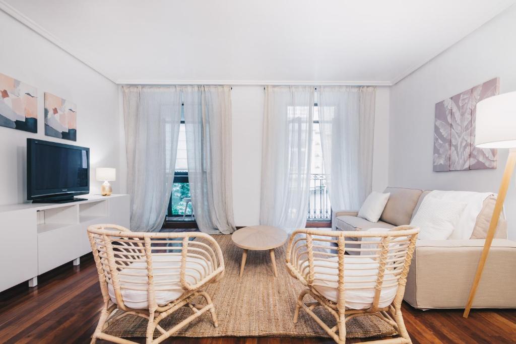 uma sala de estar com um sofá e duas cadeiras em Udaberri Apartment by People Rentals em San Sebastián