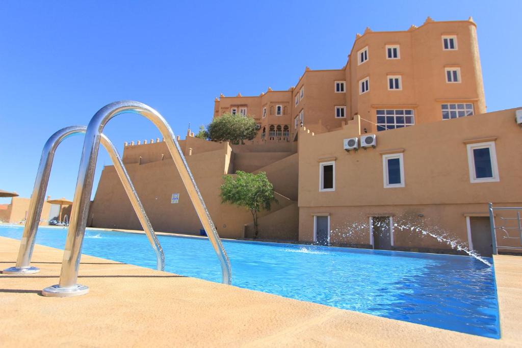 uma piscina com um escorrega em frente a um edifício em Kasbah Didis em Aït Ougliff