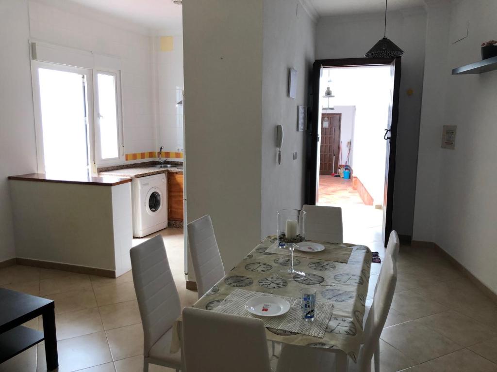 comedor con mesa y sillas y cocina en Casa LA VIÑA, en Almonte