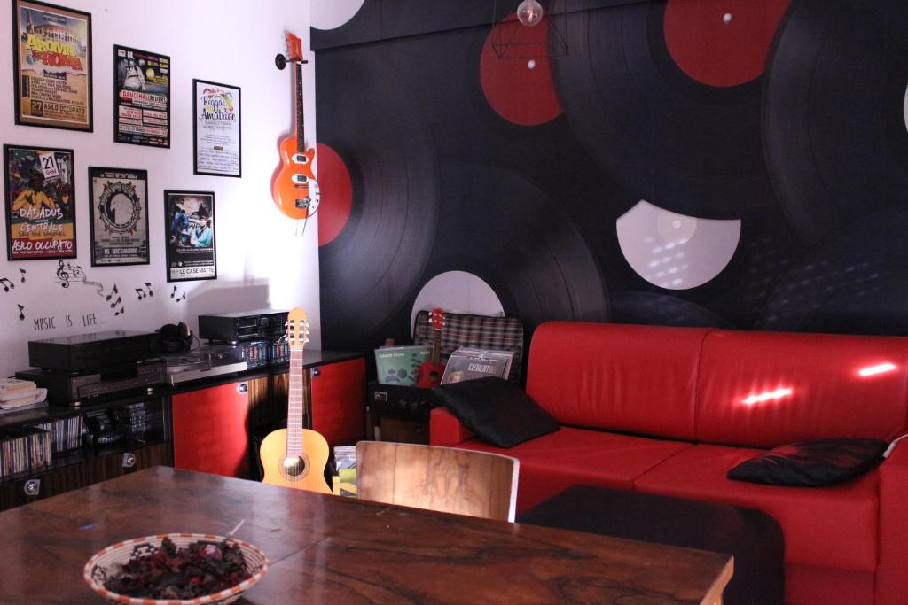 uma sala de estar com um sofá vermelho e uma mesa em House of music em LʼAquila