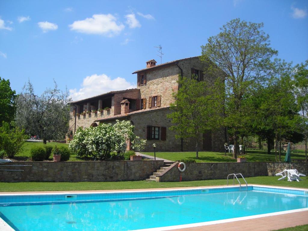 a house with a swimming pool in front of a building at Agriturismo Casagrande in Montepulciano