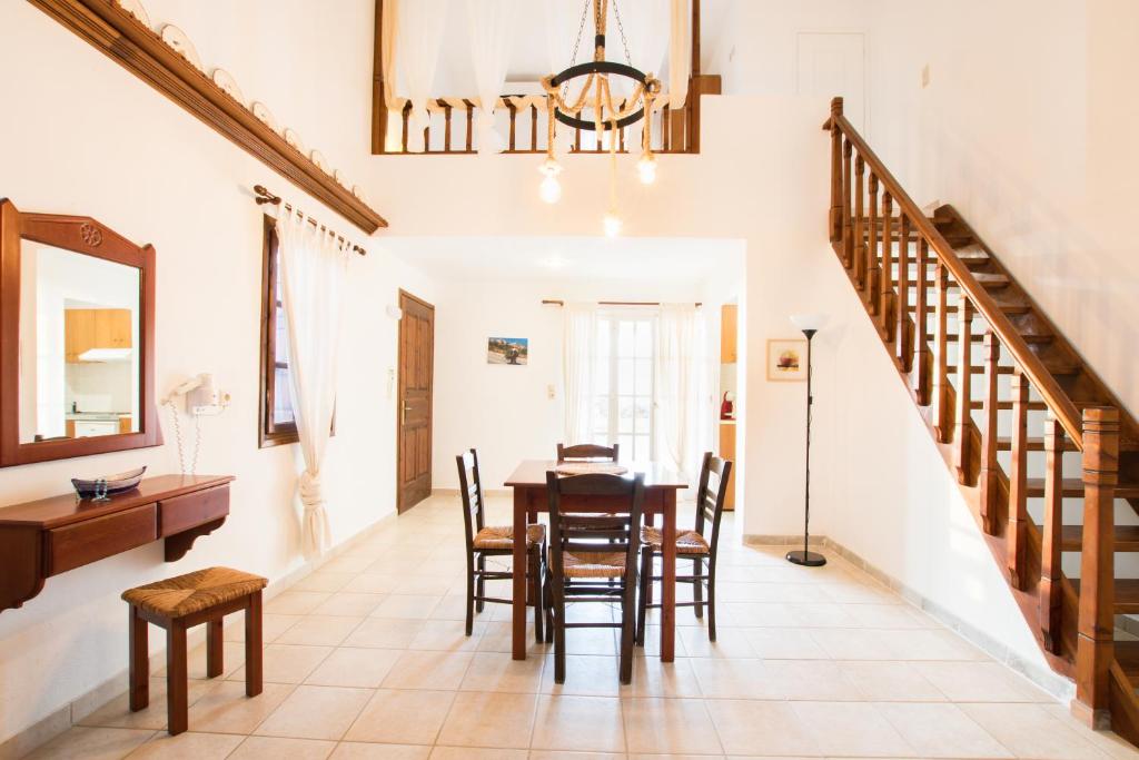 a dining room with a table and chairs and a staircase at Jhonathan in Amoopi