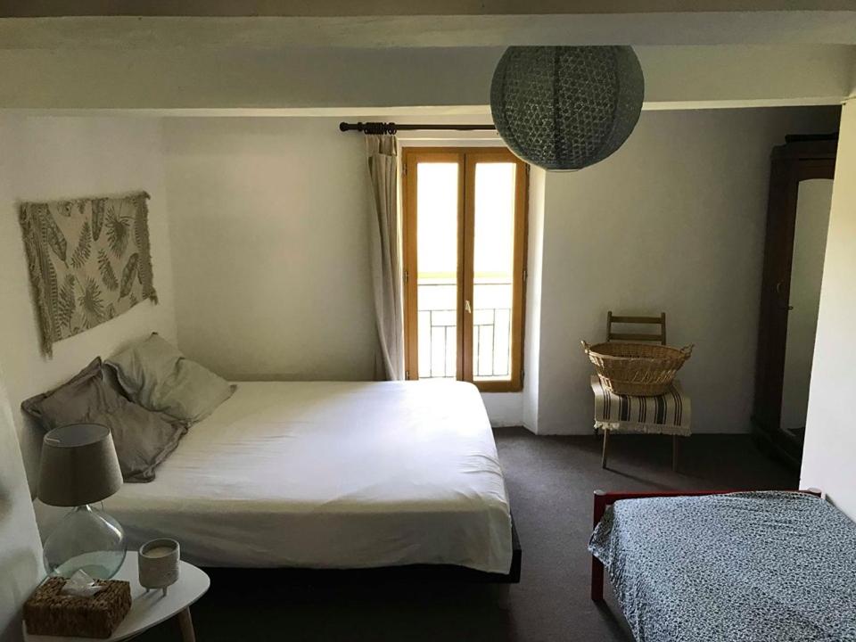 1 dormitorio con cama blanca y ventana en Gîte à la ferme Le Cabro, en Lambert