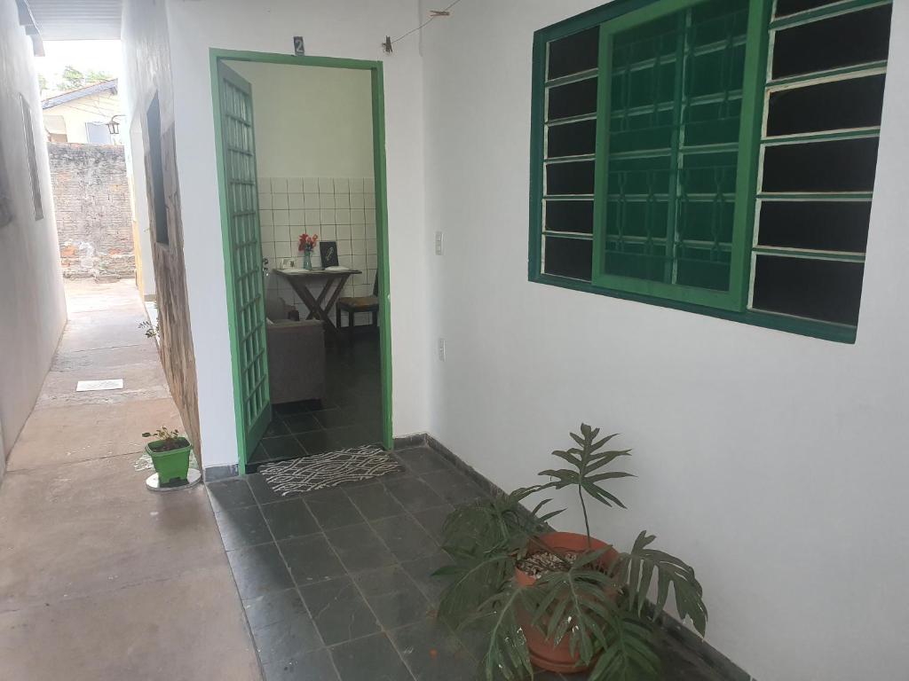 uma casa de banho com uma porta verde e uma planta em suite 02 - privativa, aconchegante e independente em Cuiabá