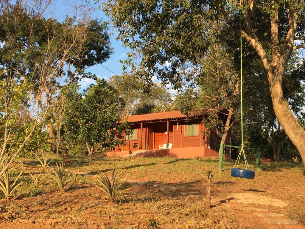ein Haus inmitten eines Gartens mit Schaukel in der Unterkunft Rancho Ecologico Oasis de Luz in Abadiânia