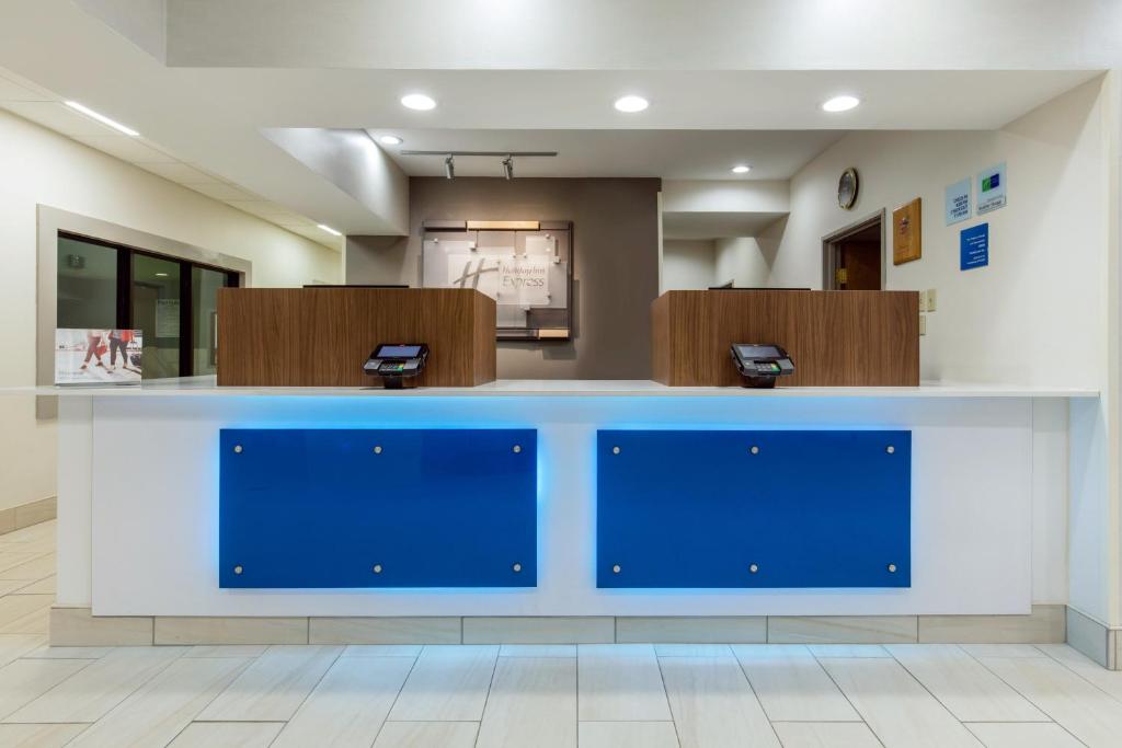 a reception desk in a waiting room with blue doors at Holiday Inn Express Henderson, an IHG Hotel in Henderson