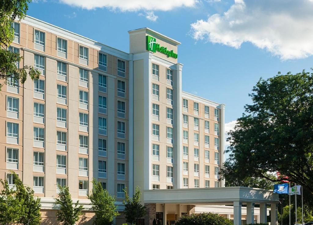 a building with a green sign on top of it at Holiday Inn Hartford Downtown Area, an IHG Hotel in East Hartford