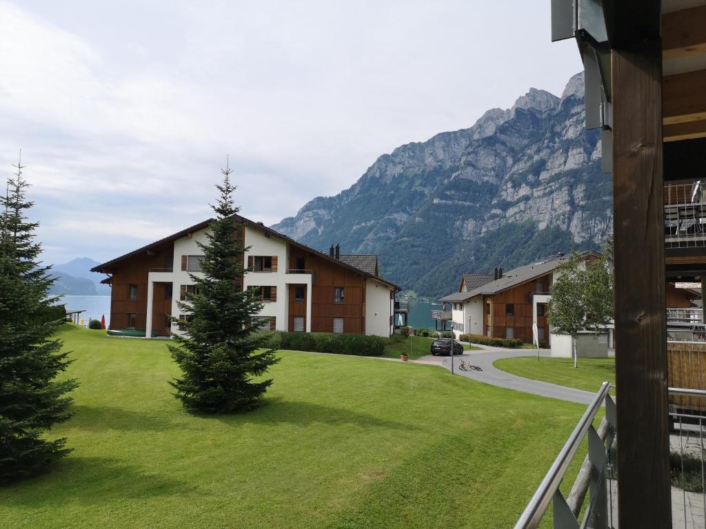 a view of a house with mountains in the background at Ferienwohnung Resort Walensee 98 - Seehöckli in Quarten