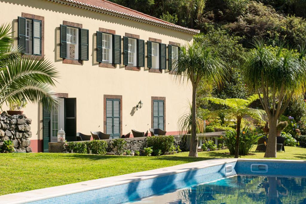 a house with a swimming pool in front of a house at Casa Da Piedade in São Vicente