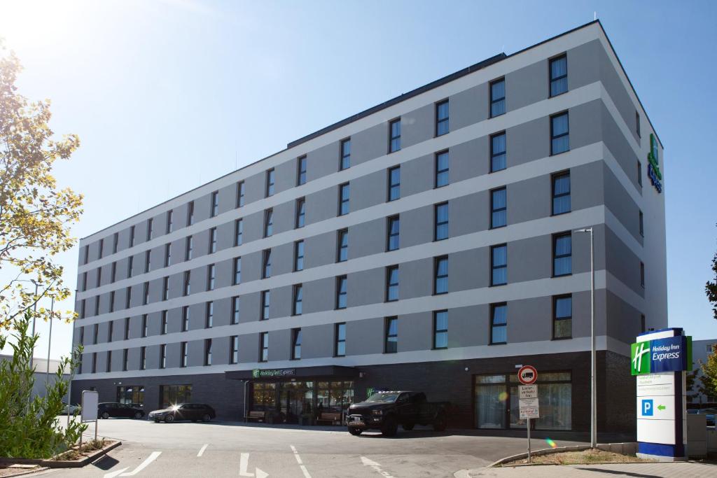 ein Bürogebäude mit einem davor geparkt in der Unterkunft Holiday Inn Express Frankfurt Airport - Raunheim, an IHG Hotel in Raunheim