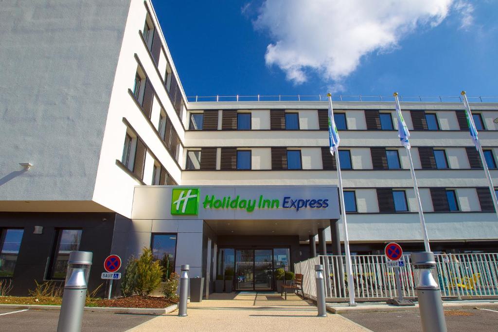 um edifício de escritórios com um sinal para o Expresso de Melbourne Inn em Holiday Inn Express Dijon, an IHG Hotel em Dijon