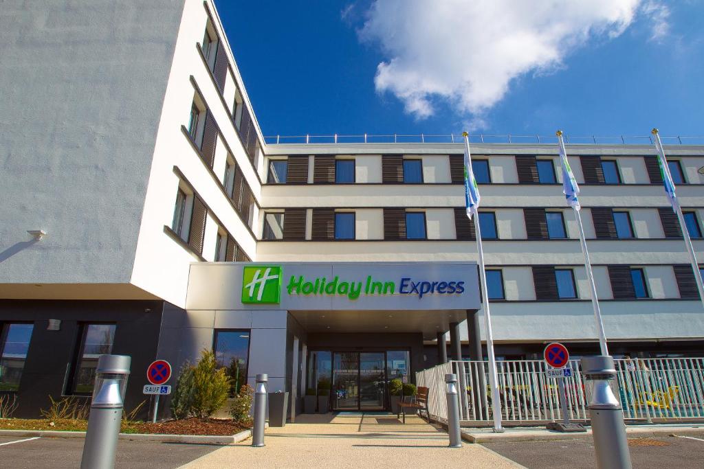un edificio de oficinas con un cartel para el Melbourne inn express en Holiday Inn Express Dijon by IHG, en Saint-Apollinaire