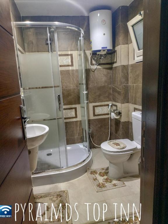 a bathroom with a shower and a toilet and a sink at Pyramids Top Inn in Cairo