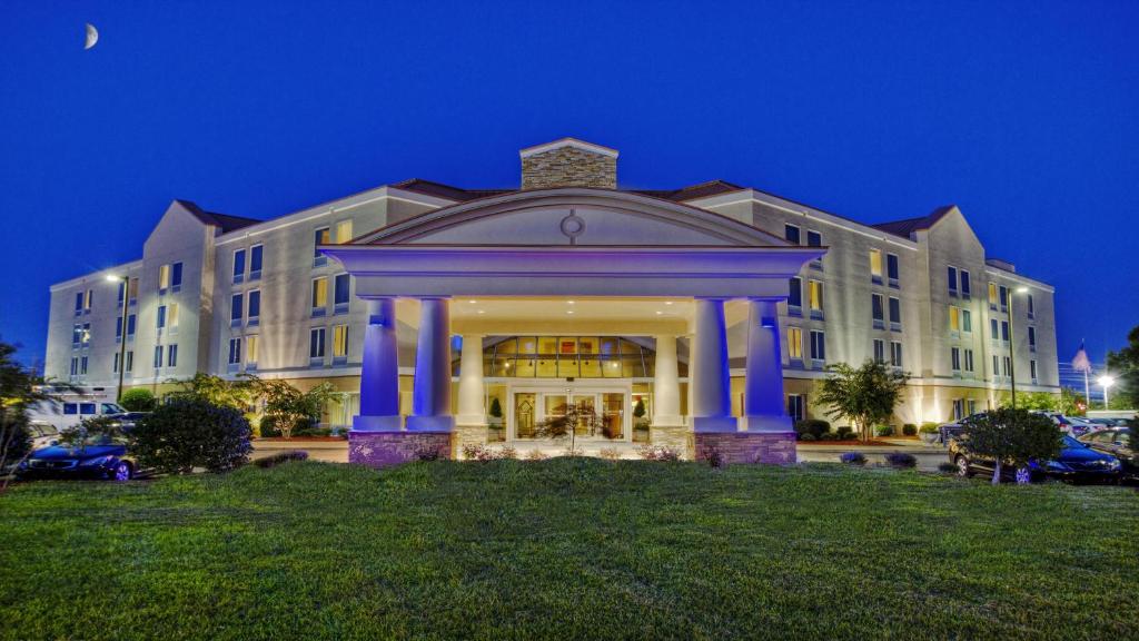 un gran edificio con columnas azules en un césped en Holiday Inn Express Greenville, an IHG Hotel, en Greenville