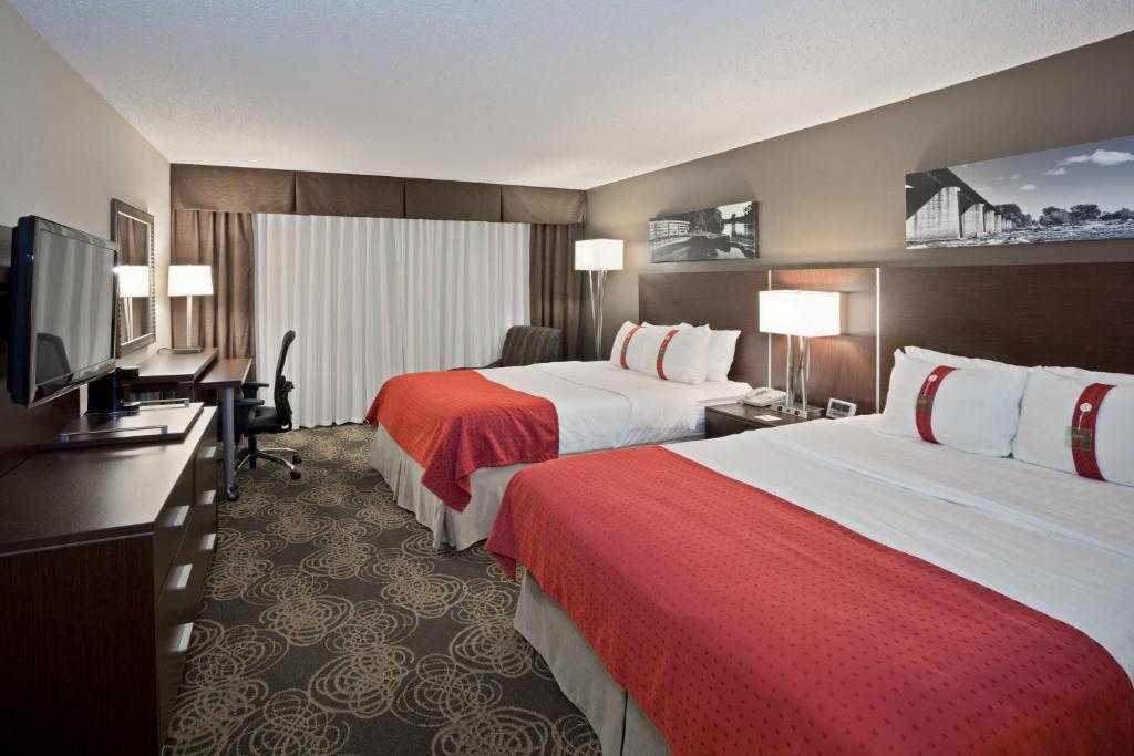 スーフォールズにあるHoliday Inn Sioux Falls-City Center, an IHG Hotelのベッド2台、薄型テレビが備わるホテルルームです。