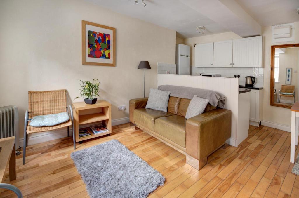 ein Wohnzimmer mit einem Sofa und einer Küche in der Unterkunft The Shop By Treetop Property in Cirencester