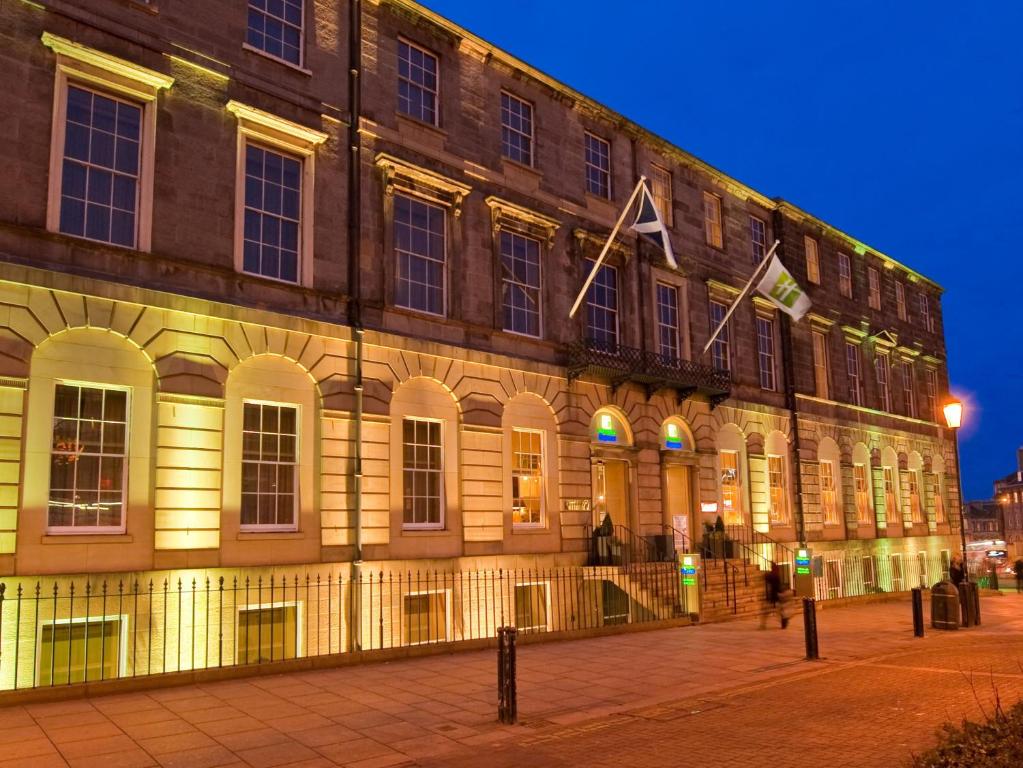 un gran edificio con luces en el lateral en Holiday Inn Express Edinburgh City Centre, an IHG Hotel en Edimburgo