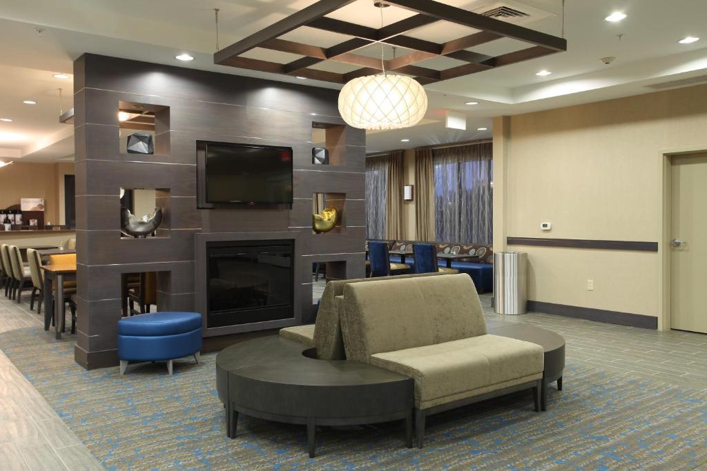 a waiting room with a fireplace and a tv at Holiday Inn Express Hotel & Suites Goldsboro - Base Area, an IHG Hotel in Goldsboro