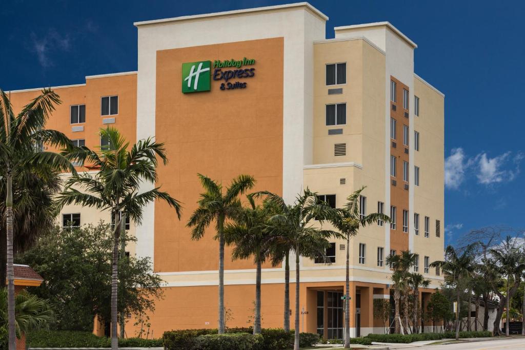 a large building with palm trees and palm trees at Holiday Inn Express Fort Lauderdale Airport South, an IHG Hotel in Dania Beach