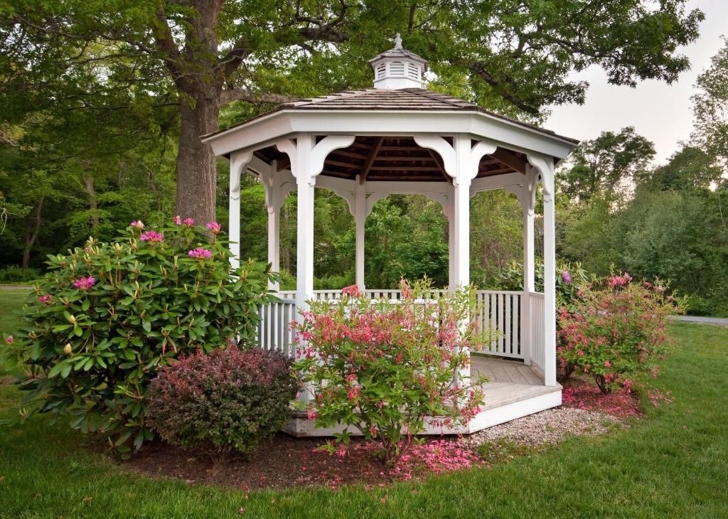 a white gazebo in a yard with flowers at Holiday Inn Cape Cod-Falmouth, an IHG Hotel in Falmouth