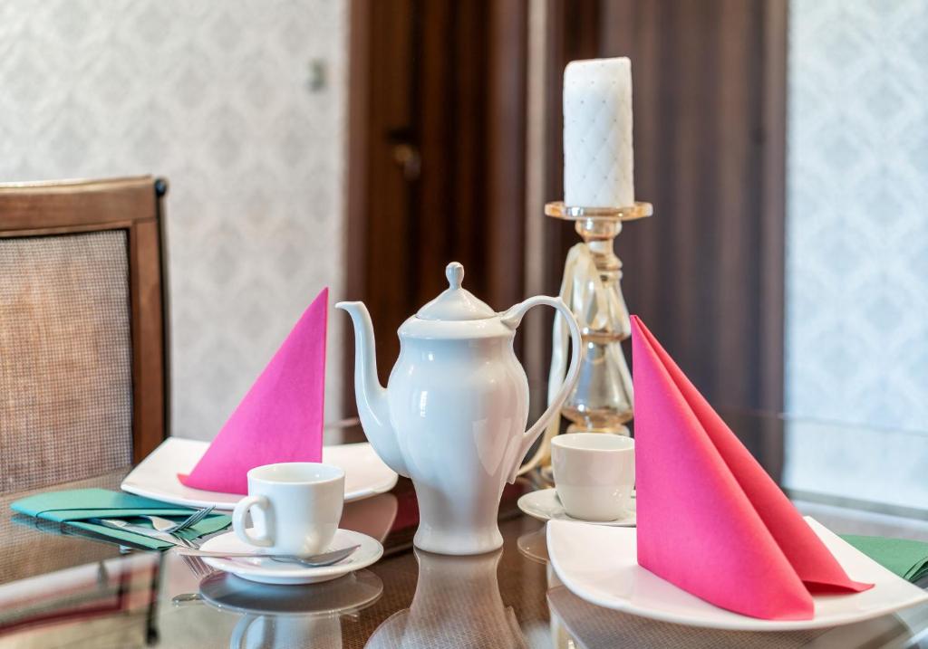 a table with pink and white napkins and a candle at Villa Zdrojowa in Otmuchów