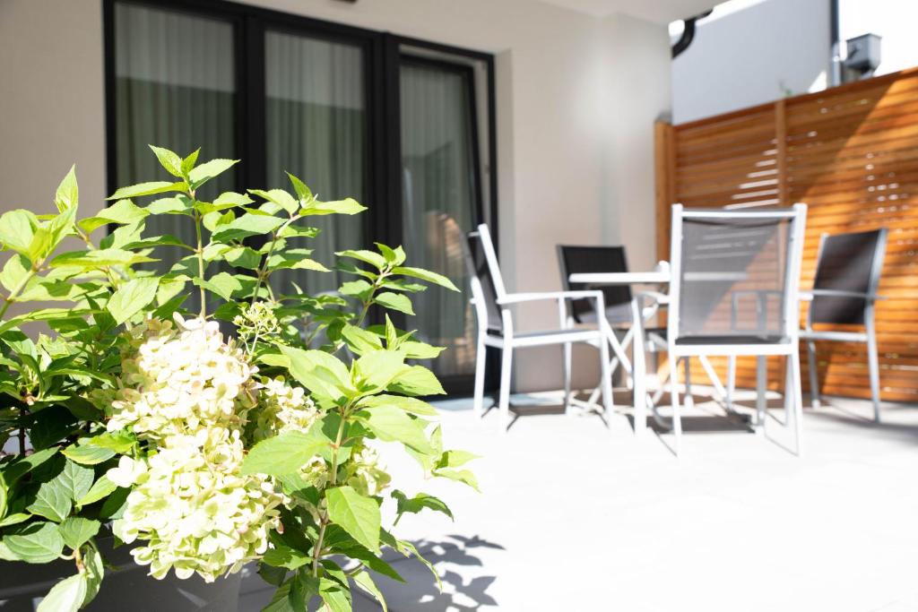 een balkon met een tafel, stoelen en bloemen bij Appartements Freiraum in Schladming