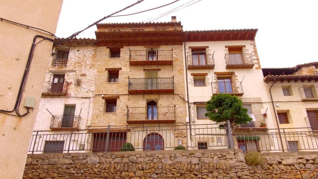 un edificio antiguo con balcones a un lado. en Apartamento Carrascales o Pinar Ciego, en Mosqueruela