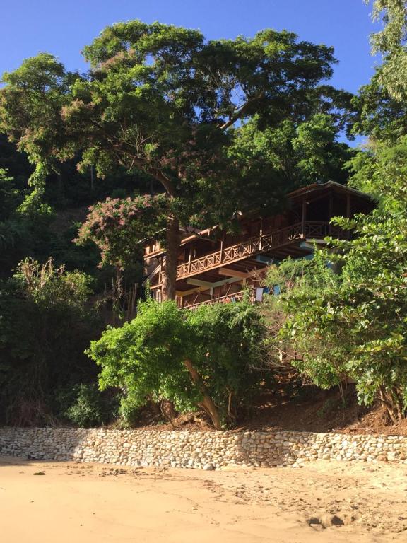 un edificio sul lato di una spiaggia con alberi di Alibaba‘s Seabreeze a Castara