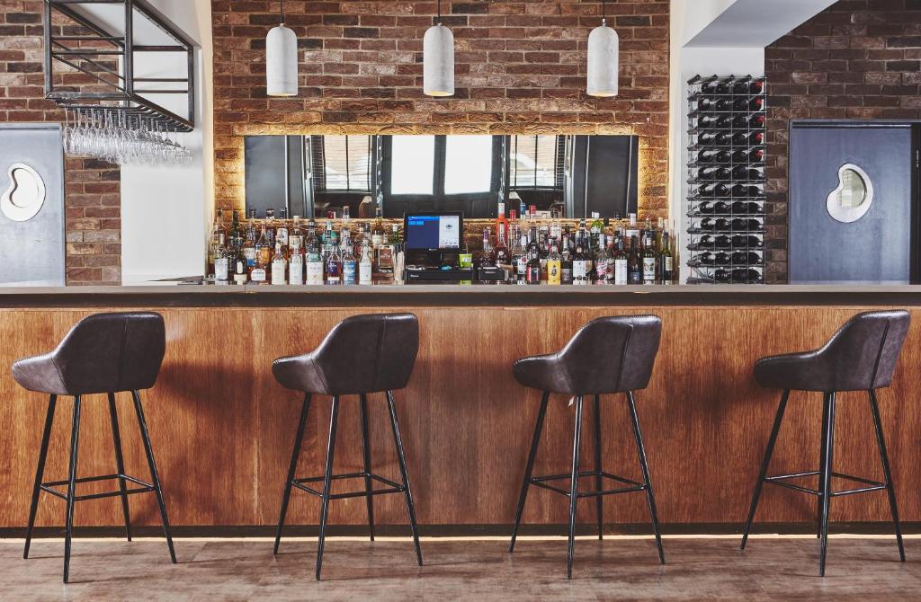 een bar met vier krukken voor een balie bij The Scot in Oban