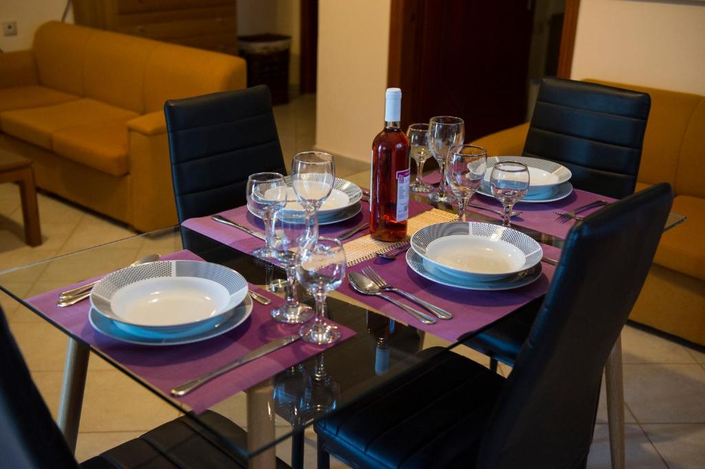 a table with glasses and plates and a bottle of wine at Zante Xigia Bay villas in Khartáta