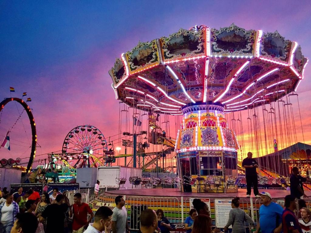 a carnival with a ferris wheel and a crowd of people at Crowne Plaza Dallas Market Ctr - Love Field, an IHG Hotel in Dallas