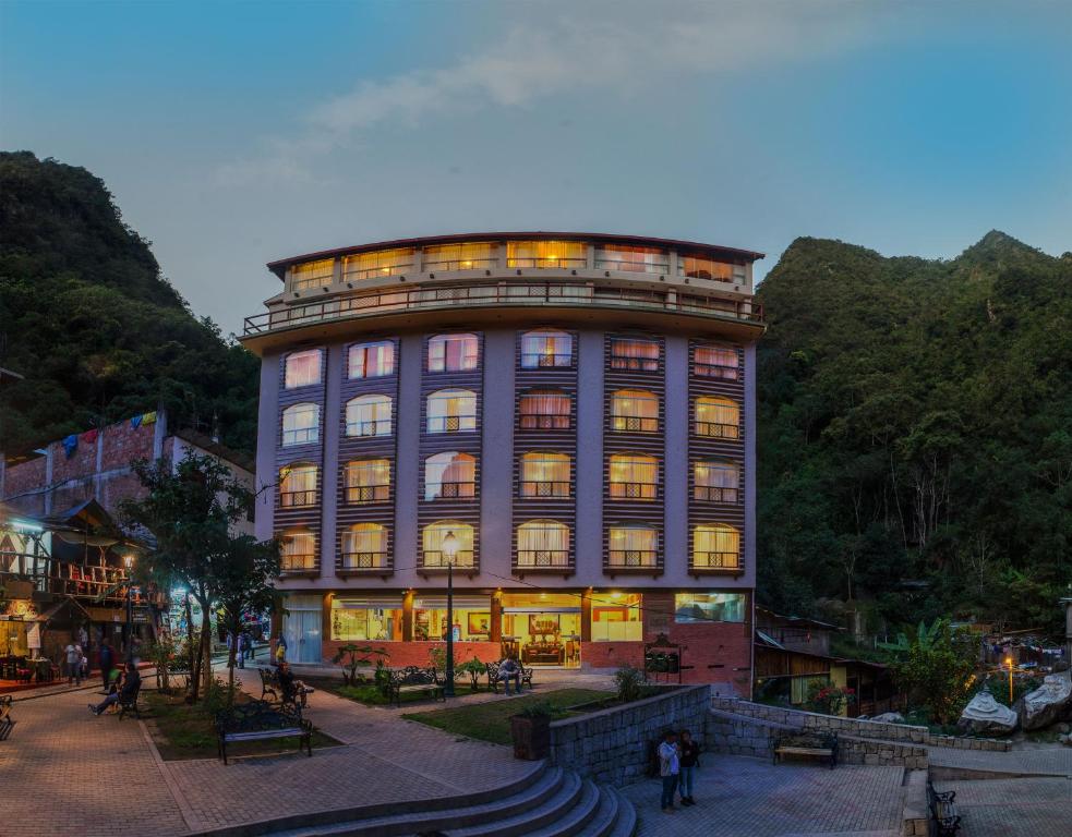 a large building with people standing in front of it at Hotel Taypikala Machupicchu in Machu Picchu