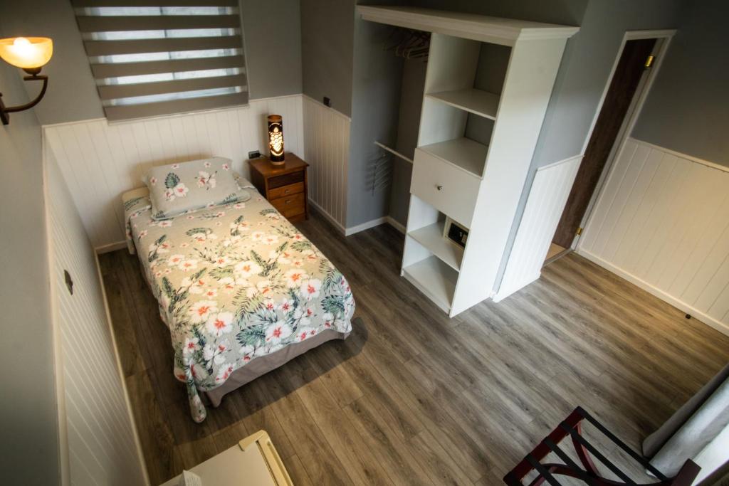 a small bedroom with a bed and a book shelf at Inaki Uhi Hotel in Hanga Roa