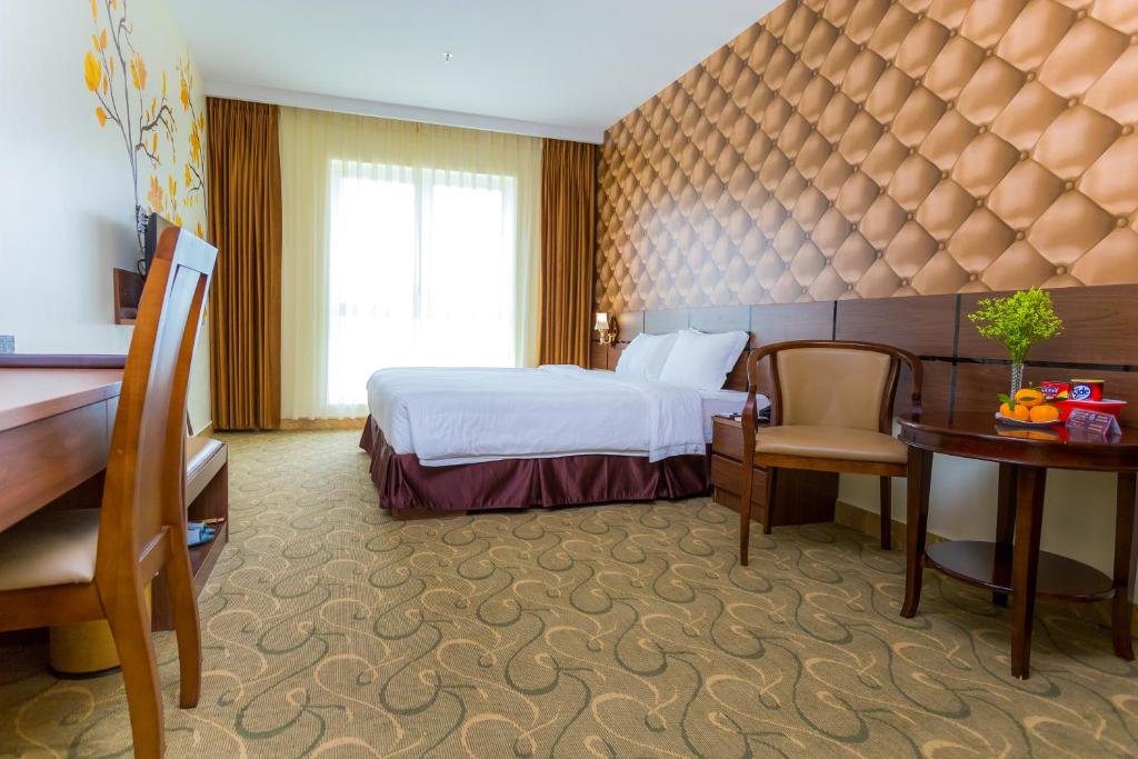 a hotel room with a bed and a desk at 3MG Lakeside Hotel in Hai Phong