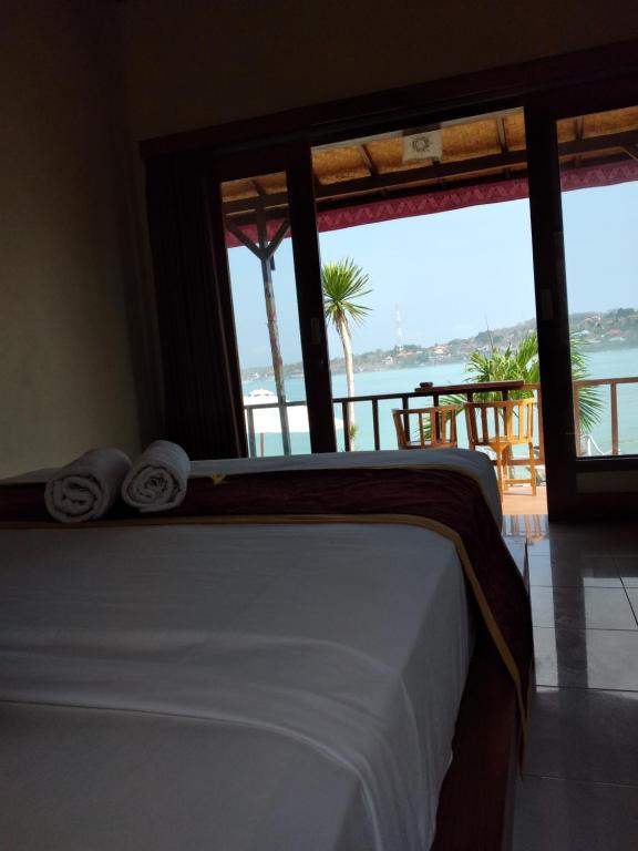 sypialnia z łóżkiem i widokiem na ocean w obiekcie Double'A beach house w mieście Nusa Lembongan