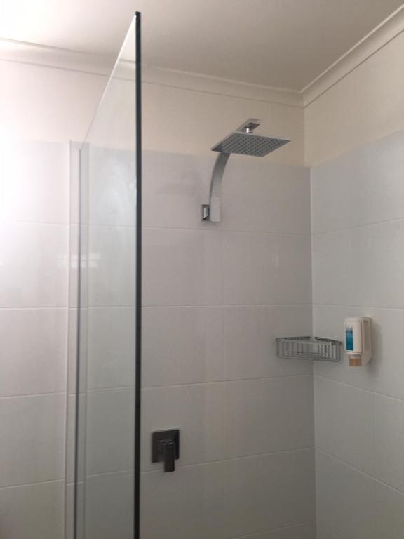 a shower with a glass door in a bathroom at Argosy Motor Inn in Devonport