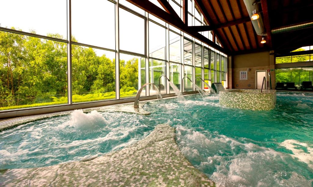 a large hot tub in a building with windows at Hotel Spa Attica21 Villalba in Villalba