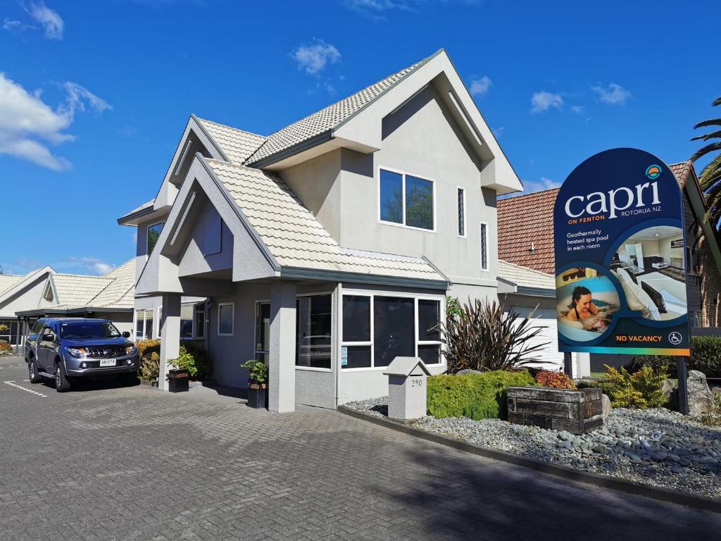 una casa con un cartel de alquiler de coches delante de ella en Capri on Fenton en Rotorua